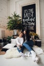 Close-up photo of little girl in knitted sweater kiss her mother while sitting on sofa at Christmas Royalty Free Stock Photo