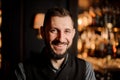 Close-up photo of male bartender with beard in bar