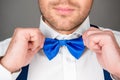 Close up photo of man correcting his bow tie