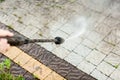 Close up photo of a man hands, cleans a tile of grass in his yard. High pressure cleaning