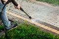 Close up photo of a man hands, cleans a tile of grass in his yard. High pressure cleaning