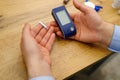 Close up photo a man holding glucometer and stripes in his hands for checking blood sugar level, diabetes concept. Royalty Free Stock Photo