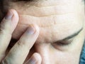 A close-up photo of a man leaning his fingers to his forehead, closing his eyes, showing a headache Royalty Free Stock Photo