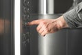 Close up photo, man pushes the floor button in the elevator. Business man hand pressing the button in the elevator. Background.