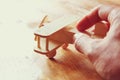 Close up photo of man's hand holding wooden toy airplane over wooden background. filtered image. aspiration and simplicity concep Royalty Free Stock Photo