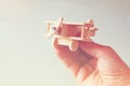 Close up photo of man's hand holding wooden toy airplane over wooden background. filtered image. aspiration and simplicity concept Royalty Free Stock Photo