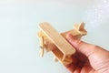 Close up photo of man's hand holding wooden toy airplane over wooden background. filtered image. aspiration and simplicity concept Royalty Free Stock Photo