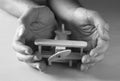 Close up photo of man's hand holding wooden toy airplane over wooden background. filtered image. aspiration and simplicity concept Royalty Free Stock Photo