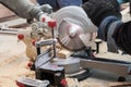 Close up photo of mans hands hold electric saw mill with sharp blade and cut part of wooden block