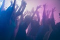 Close up photo of many birthday party people dancing clubbing purple lights confetti fog nightclub hands raised shiny