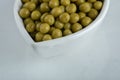 Close up photo of marinated green olives in white bowl Royalty Free Stock Photo