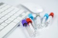 Medicine bottles for samples next to computer tablet and computer keyboard in medicine, closeup on white background