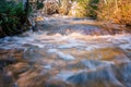 Close up photo of melted snow water in forest creek runs through Scandinavian forest. Vey Sunny spring day. Long exposure for Royalty Free Stock Photo