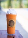 Close-up photo of milk iced tea in a plastic cup placed on a wooden table Royalty Free Stock Photo