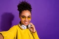 Close up photo of modern cute teen make photos moment video call have earphone yellow pullover isolated over violet Royalty Free Stock Photo