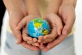 Mother and daughter holding world globe in eduction and protection concept Royalty Free Stock Photo