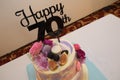 A close up photo of a multiple tiered seventieth colorful birthday cake