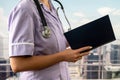 close-up photo of a nurse in uniform holding a journal and taking notes in a hospital. Royalty Free Stock Photo