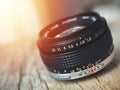 Close up photo of old camera lens over wooden table. Image is retro filtered. selective focus, lens flare Royalty Free Stock Photo