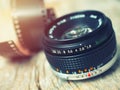 Close up photo of old camera lens over wooden table. Image is retro filtered. selective focus, lens flare Royalty Free Stock Photo