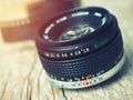 Close up photo of old camera lens over wooden table. Image is retro filtered. selective focus, lens flare Royalty Free Stock Photo