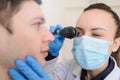 close up photo of a optometrist examining man`s eyes