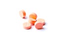 Close-up photo of orange pills isolated on white background