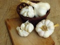 Close up Photo of Organic Whole Garlic with some Unpeeled Cloves and a clove of garlic on oak tree wood background.