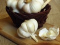 Close up Photo of Organic Whole Garlic with some Unpeeled Cloves and a clove of garlic on oak tree wood background.