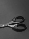 Close up photo of a pair of scissors on a dark background.