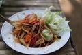 Close-up photo Papaya Salad with Pickled Crab, a popular Asian spicy dish with fermented fish and garlic fish sauce.