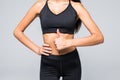 Close up photo of perfect fit slim woman`s belly and thumb up on gray background Royalty Free Stock Photo