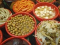 Close-up photo of pickled garlic, lettuce, plum,  cucumber, carrot, cabbage, green pepper and beet in the plastic bowls at bazaar. Royalty Free Stock Photo