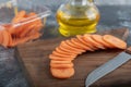 Close up photo of pile of carrot slices on wooden chopping board