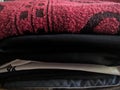 A close-up photo of a pile of clothing with someone holding a cell phone. This asset is suitable for fashion websites.