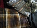 A close-up photo of a pile of clothing with someone holding a cell phone. This asset is suitable for fashion websites.