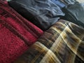 A close-up photo of a pile of clothing with someone holding a cell phone. This asset is suitable for fashion websites.