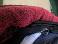 A close-up photo of a pile of clothing with someone holding a cell phone. This asset is suitable for fashion websites.