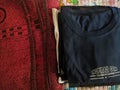 A close-up photo of a pile of clothing with someone holding a cell phone. This asset is suitable for fashion websites.