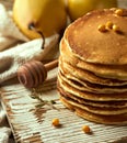 Close-up photo of a pile of fluffy buttermilk pancakes on a bright wooden surface, with a pair of pears in the distance, sea Royalty Free Stock Photo