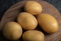 Close up photo of pile of potatoes on wooden cutting board