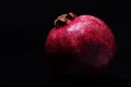 Close-up photo of the pomegranate on black background isolated