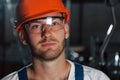 Close up photo. Portrait of engineer in metallurgical factory in protective helmet and eyewear