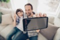 Close up photo portrait of positive relaxed nice glad daddy making selfie with his younger son on telephone sitting on Royalty Free Stock Photo