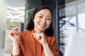 Close up photo portrait of young beautiful Asian woman, business woman smiling and looking at camera, receptionist using Royalty Free Stock Photo