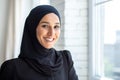 Close-up photo. Portrait of a young beautiful Muslim woman in a black hijab looking confidently and smiling at the Royalty Free Stock Photo