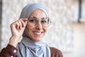 Close-up photo. Portrait of a young beautiful Muslim woman in a hijab smiling looking at the camera and adjusting her Royalty Free Stock Photo