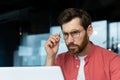 Close-up photo. Portrait of a young male programmer, a businessman who is concentrating on working in the office at a