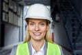 Close-up photo. Portrait of a young smiling female architect, engineer, worker in a safety helmet standing outside a Royalty Free Stock Photo