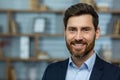 Close-up photo of a portrait of a young successful businessman, lawyer, broker standing in a suit in the office, smiling Royalty Free Stock Photo